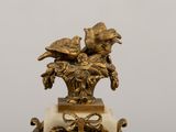 a statue of two birds sitting on top of a clock