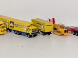 many toy trucks lined up in a row on a white surface