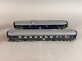 two train cars sitting side by side on a white surface