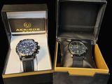 two watches in a box on a black surface
