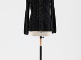 une veste noire posée sur un mannequin, sur fond blanc
