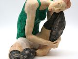 a figurine of a man kneeling on a rock