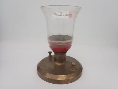 un petit vase en verre contenant une substance rouge