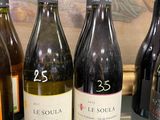 several bottles of wine are lined up on a counter