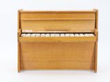 a wooden piano that is sitting on a white surface