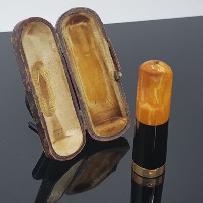 a small box with a lipstick in it on a table