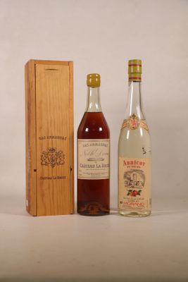 two bottles of alcohol sit next to a wooden box on a white surface