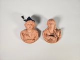 deux figurines représentant un homme et une femme sont assises sur une surface blanche