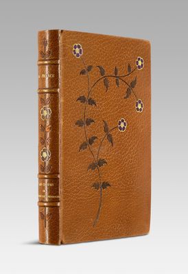 a brown leather book with flowers and leaves on it