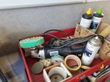 a red cart filled with assorted items on the floor