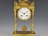 une horloge en or surmontée d'un oiseau