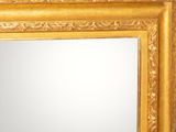 a mirror with a gold frame on the wall