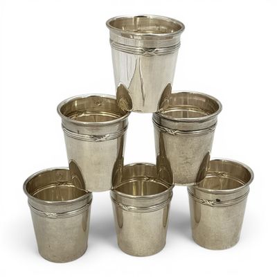 six coupes en argent sont disposées en pyramide sur une surface blanche