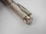 an image of a silver pen sitting on top of a white table