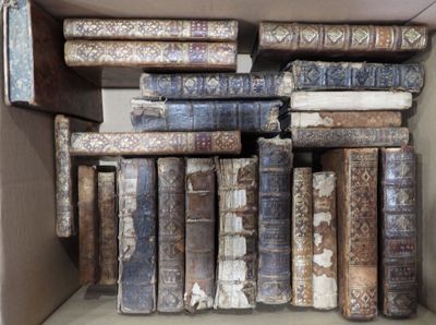 une boîte remplie de vieux livres posée sur une étagère