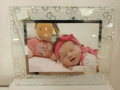 a picture of a baby in a picture frame with a teddy bear