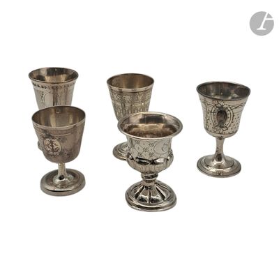 Plusieurs gobelets et tasses en argent sont alignés sur une surface blanche