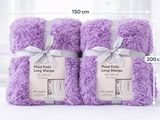Trois serviettes violettes sont empilées les unes sur les autres sur une table