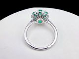 an image of a diamond and emerald ring on display