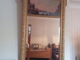 un grand miroir au milieu d'une chambre où se trouve un lit