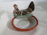 figurine en porcelaine d'un poulet assis sur un bol