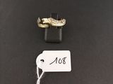 two gold wedding rings with a price tag on a black background