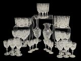 beaucoup de verres à vin et un pichet posés sur une table