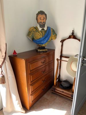 une statue représentant un homme posée sur une commode dans une pièce