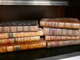 Plusieurs vieux livres sont empilés sur une étagère d'une bibliothèque
