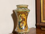 un vase posé sur une table en bois devant un tableau
