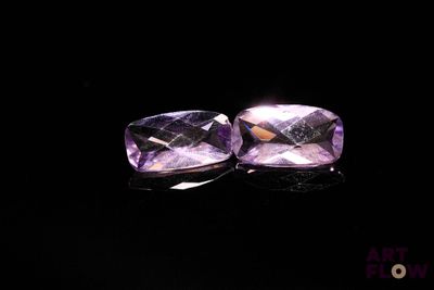 deux améthystes violettes sur une surface noire, avec un fond noir