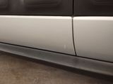 the side of a white truck with black trims parked in a parking lot