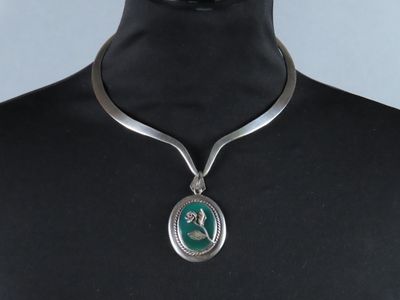 collier en argent avec un pendentif vert autour du cou d'un mannequin