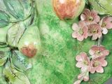 a green plate with fruit and flowers on it