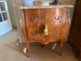a wooden chest of drawers with a gold tassel on top of it