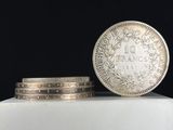 une pièce d'argent posée au sommet d'une pile de pièces