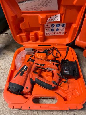 an orange tool case with tools in it sitting on the ground