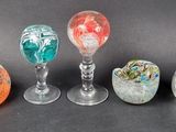 six different colored glass vases sitting on top of a black surface
