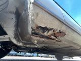 a close up of a car ' s bumper with rust on it