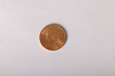 a gold coin sitting on top of a white surface