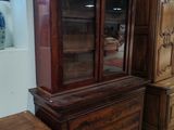 une armoire en bois avec une porte vitrée, à côté d'une commode