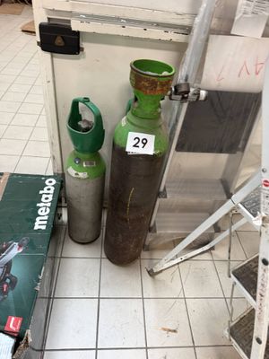 two propane gas bottles on the floor next to a ladder