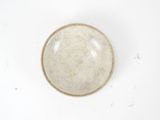 a white bowl with a brown rim on a white surface