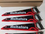 a set of four red and black hand saws sitting on top of a cardboard box