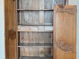 a wooden cabinet with a door open on a hard wood floor