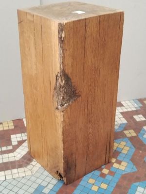 a piece of wood that is sitting on a tiled floor