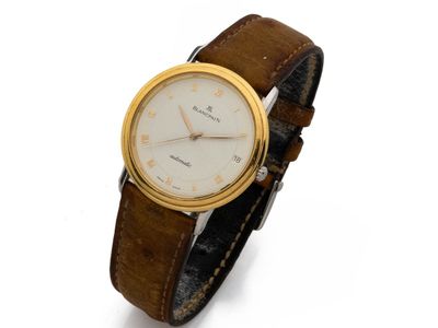 gros plan d'une montre sur une surface blanche avec un bracelet marron