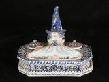 a blue and white figurine with a hat on top of it