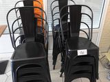 four black metal chairs sitting in front of a window
