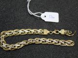 a close up of a gold chain bracelet with a tag on it